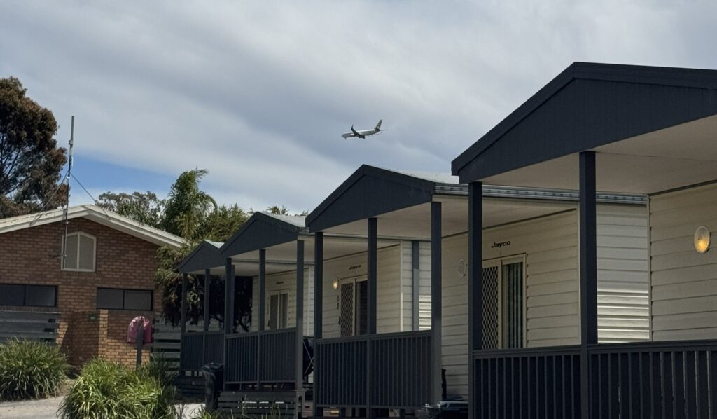 Plane flying over cabin. Where to stay near Melbourne Airport for early morning international flights